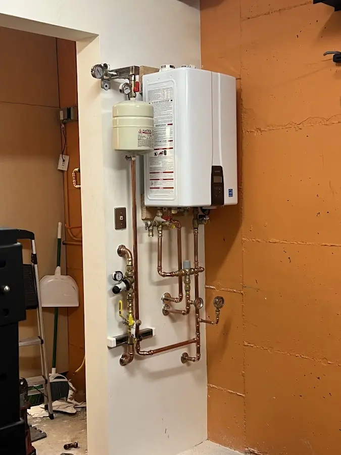 Plumbing technician inspecting water heater connections in Las Lomas
